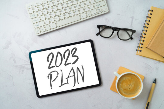 New Year 2023 Plans And Goals Business Concept With Digital Tablet, Coffee Cup And Computer Keyboard On Modern Office Desk. Top View, Flat Lay