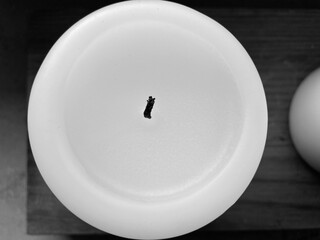 A round white candle with black wick from above
