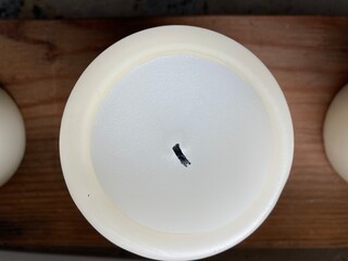 A round white candle with black wick from above