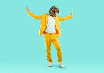 Portrait of cheerful stylish man in trendy rubber dinosaur mask dancing and fooling around. Cool...