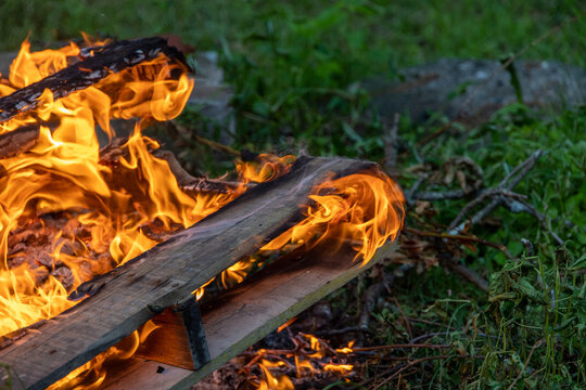 Flames and Smoke Swirling Around Burning Wood