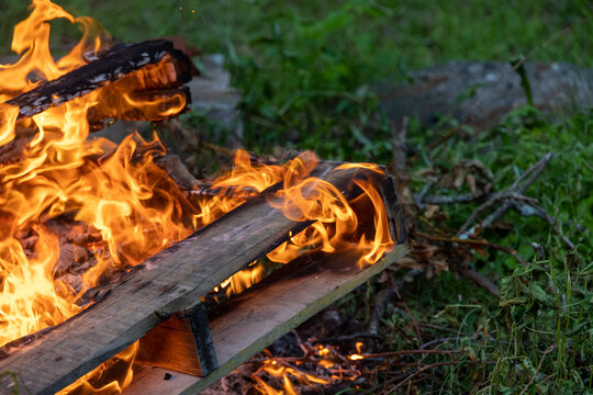 Flames and Smoke Swirling Around Burning Wood