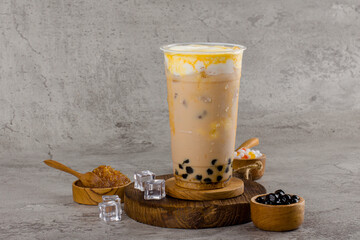 Boba or tapioca pearls is taiwan bubble milk tea in plastic cup with coffee caramel flavor on texture  background, summers refreshment.