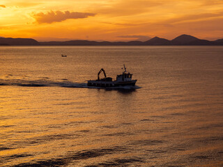Naklejka premium fishing boat at sunset