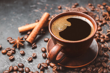 Fresh brewed black coffee in a cup on dark background with coffee beans and chocolate pieces