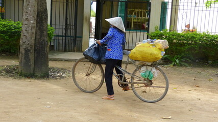 Asiatin transportiert auf ihrem Fahrrad ihren Einkauf