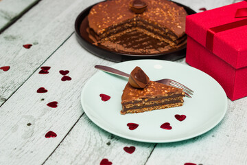 Chocolate cake served for two with gift for Valentine's Day. On wooden rustic table