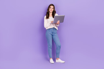 Full length photo of positive adorable lady hold netbook macbook device enjoy quality gadget speed wifi isolated on purple color background