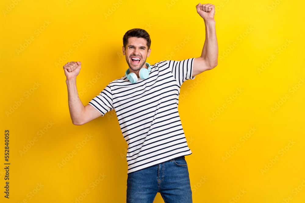 Poster portrait of delighted overjoyed person raise fists shout yes isolated on yellow color background