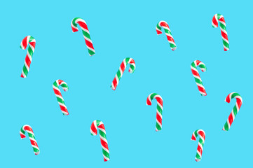 Christmas and New year pattern made of candy canes on pastel blue background.