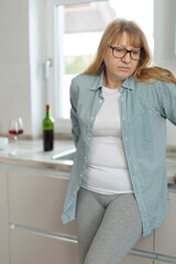 Woman drinking a glass of wine in a modern kitchen