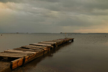 Abandoned boat platform in the Ebro Delta with a sunset in Tarragona, Spain.