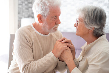 Senior woman comforting her depressed sad husband, unhappy elderly man sitting on sofa at home. Ourmindsmatter