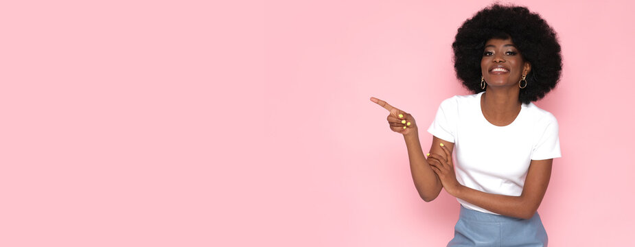 Happy afro american woman with text place on pink background.