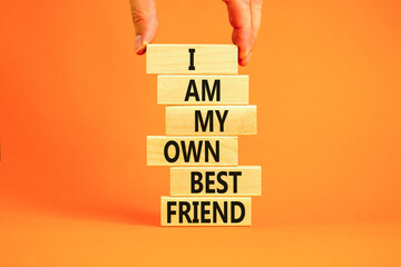 I am my own best friend symbol. Concept words I am my own best friend on wooden blocks on a beautiful orange table orange background. Businessman hand. Business i am my own best friend concept.