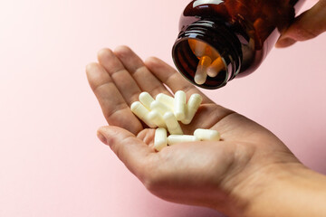 Zinc tablets in the hand on a pink background. - obrazy, fototapety, plakaty