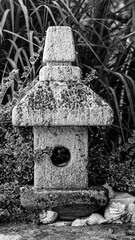 Garden decorations made of stones and stone sculptures among nice greens.