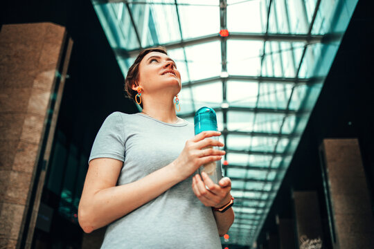 A young woman with cold drink in city