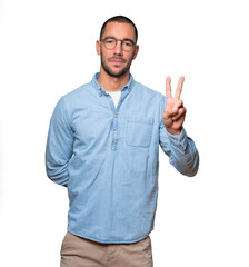 Young man making a number two gesture