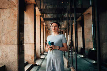 A young woman with cold drink in city