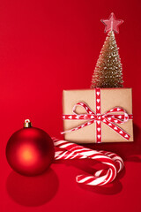 decorative Christmas trees and gift boxes on red background against red background