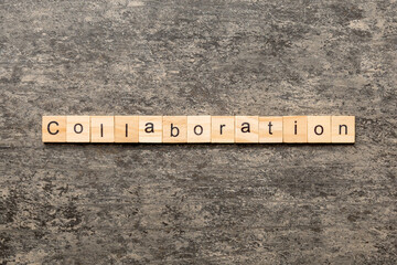 Collaboration word written on wood block. Collaboration text on cement table for your desing,...