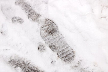Shoe tracks on white snow close up