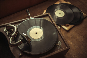 Mechanical gramophone with a wind-up handle for playing records. Vintage music music player. Retro disco.The records are on the table.