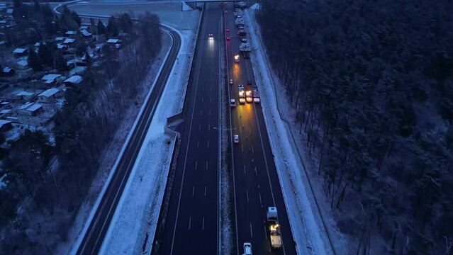 Snow-covered highway taken from the air, two lines of the road closed to traffic due to heavy transport with tunnel boring machine in winter.