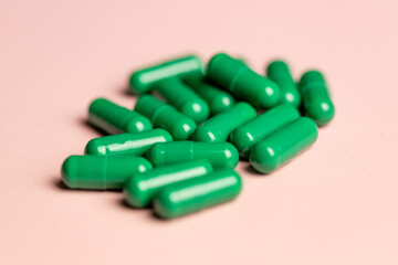 Green capsules on a pink background.