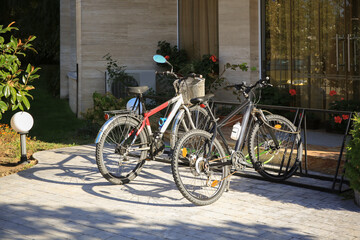 Fototapeta na wymiar Parking rack with modern bicycles near building outdoors