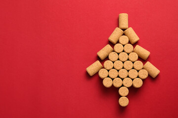Christmas tree made of wine corks on red background, top view. Space for text