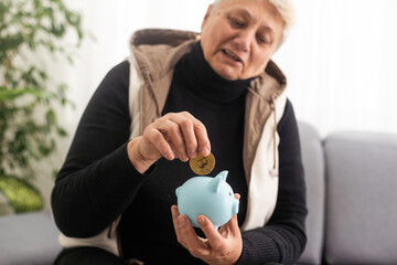 Money management concept. Senior elderly woman is holding a piggy bank