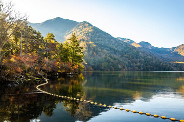 Scenic view of Yunoko lake at fall with colorful trees at sunset