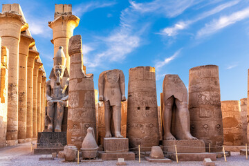 Luxor Temple, first pylon ruins and the statues of Ramses II, Egypt - obrazy, fototapety, plakaty