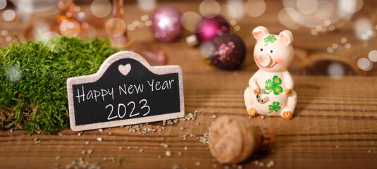 glücksschwein mit schild worauf happy new year 2023 steht
