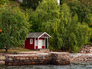 Fototapeta na wymiar Nesoddtangen, Norway - Sep, 2022: Bath houses on the seaside overlooking the fjord seen from the sighting tour on the Oslo Fjord near Oslo, municipality of Nesodden in Akershus, Northern Europe