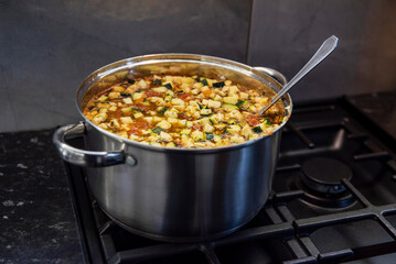 zupa toskańska gotująca się na kuchence gazowej w dużym garnku stalowym - obrazy, fototapety, plakaty