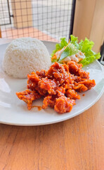 A plate of homemade Korean dish 'Dakganjeong' (sweet and spicy Korean fried chicken), served with white rice and salad