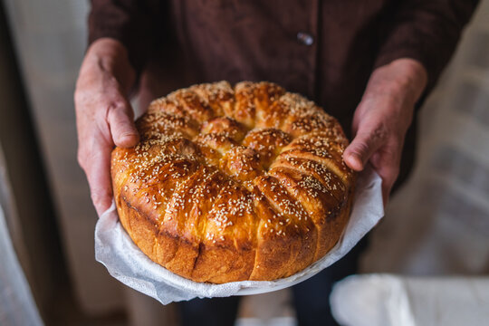 A close up of slava bread held by grandma at the village 