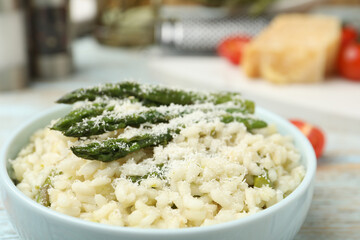 Delicious risotto with asparagus and cheese in bowl, closeup