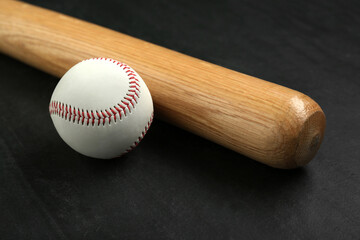 Baseball bat and ball on black background. Sports equipment