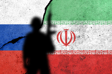 Flags of Russia and Iran painted on the concrete wall with soldier shadow.