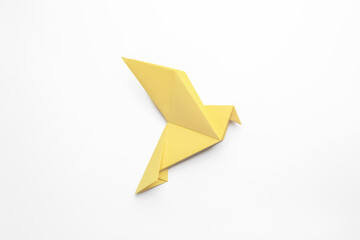 Beautiful yellow origami bird on white background, top view