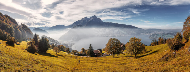 Idyllic mountain landscape in the Swiss Alps with blooming meadows, rocky mountains and calm lake...