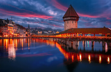 Fototapeta premium Colorful evening view of the Old Town medieval architecture in Lucerne, Switzerland. Dramatic scene with Reuss river, Chapel bridge. Wonderful vivid cityscape during sunset. popular travel destination