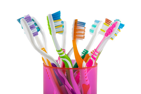 Toothbrush, toothbrush close-up. Set of toothbrushes in pink glass bowl on white background. Concept toothbrush selection, plastic.