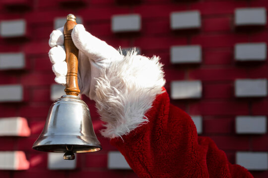 Close-up of a Santa hand holding a Christmas bell