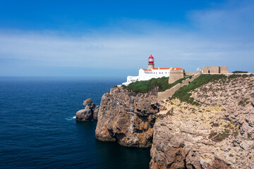 Fototapeta na wymiar Lighthouse at Cabo San Vicente in Sagres Portugal. lighthouse with blue sky with clouds and sea