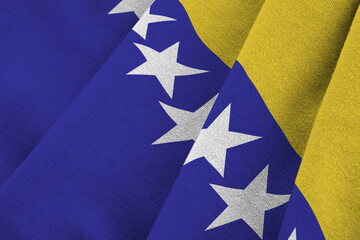 Bosnia and Herzegovina flag with big folds waving close up under the studio light indoors. The...